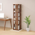 Dark wood slat rotating tower bookshelf with books in home office setting beside wooden desk with monitor and tropical plant
