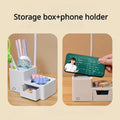 Storage box and phone holder feature showing organizer filled with stationery on left and phone placed in slot on right