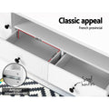Black and white extendable TV unit in grey living room below large wall-mounted TV with white raised shelf section