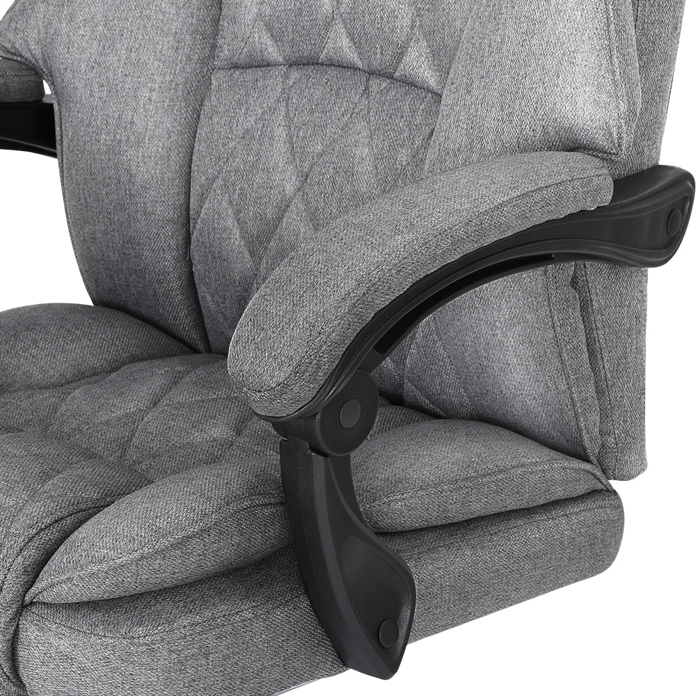 Close-up of grey fabric armrest pad with black pivot armrest mechanism against diamond-stitch back on white background