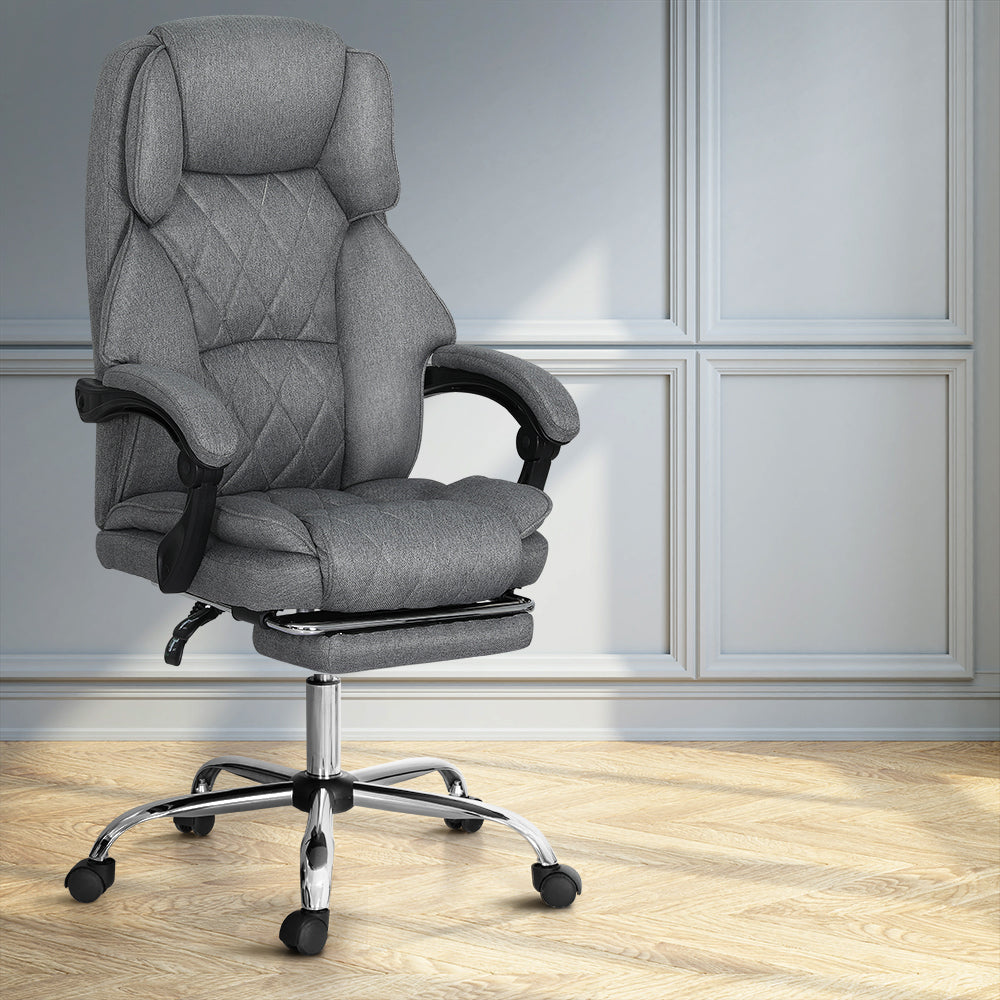 Grey fabric high-back executive chair with retractable footrest and chrome base in grey-panelled lifestyle room