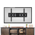 Fixed TV wall bracket shown on back of large TV above dark wood TV unit with copper vases photo frames and ornament