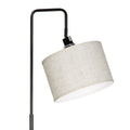 Close-up of cream linen drum shade hanging from black curved arc arm bracket, lamp socket visible at mounting