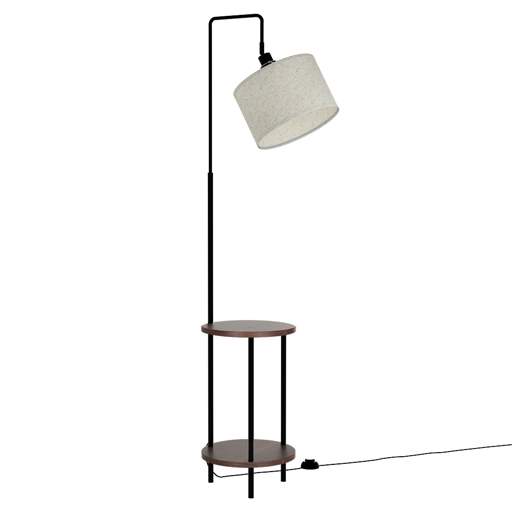 Arc floor lamp with cream drum shade and two dark walnut round shelves on black metal frame, white background