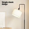 Arc floor lamp head with illuminated cream linen shade and black curved arm in room, text reads Simple classic design