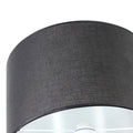 Angled top close-up of black fabric drum shade on floor lamp with silver chrome fitting visible at base of shade