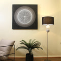 Floor lamp with black drum shade and glass ball stem in room corner beside circular wall art, palm plant in black pot