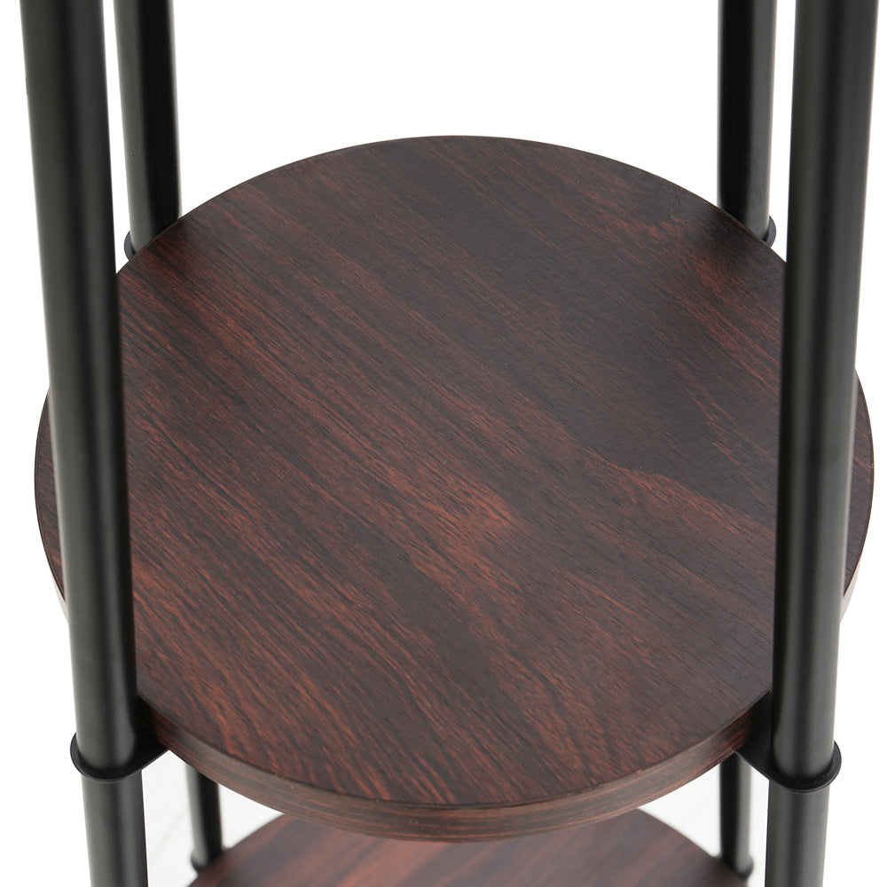 Close-up of round dark walnut-finish shelf on black metal poles, part of a multi-tier floor lamp stand