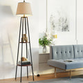 Shelf floor lamp with beige linen shade and two dark walnut tiers on black frame next to grey sofa in living room