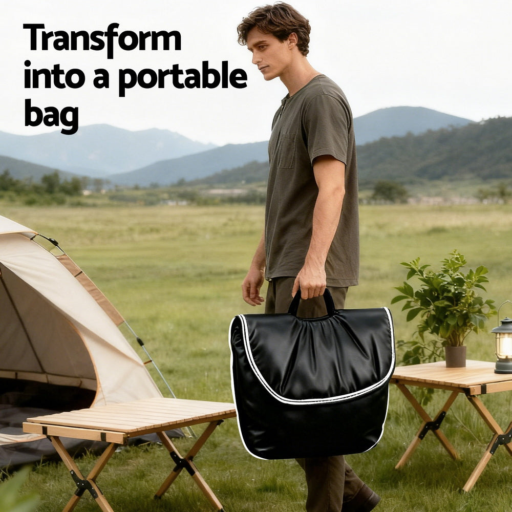 Man carrying folded black floor chair as a portable bag at campsite, text reads "Transform into a portable bag"
