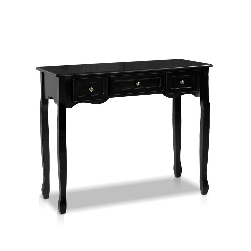 Black wooden console table with three drawers and ornate cabriole legs styled with flowers and lamp by staircase