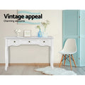 White French provincial console in room with blue vases and vanity mirror; Eames chair beside; text 