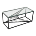 Rectangular clear glass-top coffee table with black metal starburst wire base on white background, side view showing base