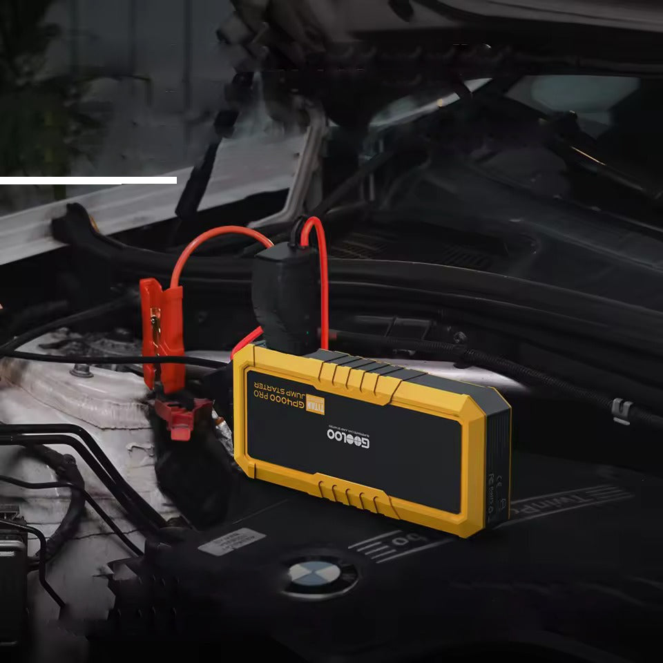 GOOLOO GP4000 Pro Titan jump starter on BMW engine bay connected to car battery with red and black clamps