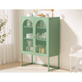 Sage green arched sideboard in light room, dishes and teapot visible through mesh doors, kitchen items and pastry on top