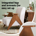 Dark green corduroy wingback accent chair with back cushion and black legs, cane sideboard and round side table with lamp