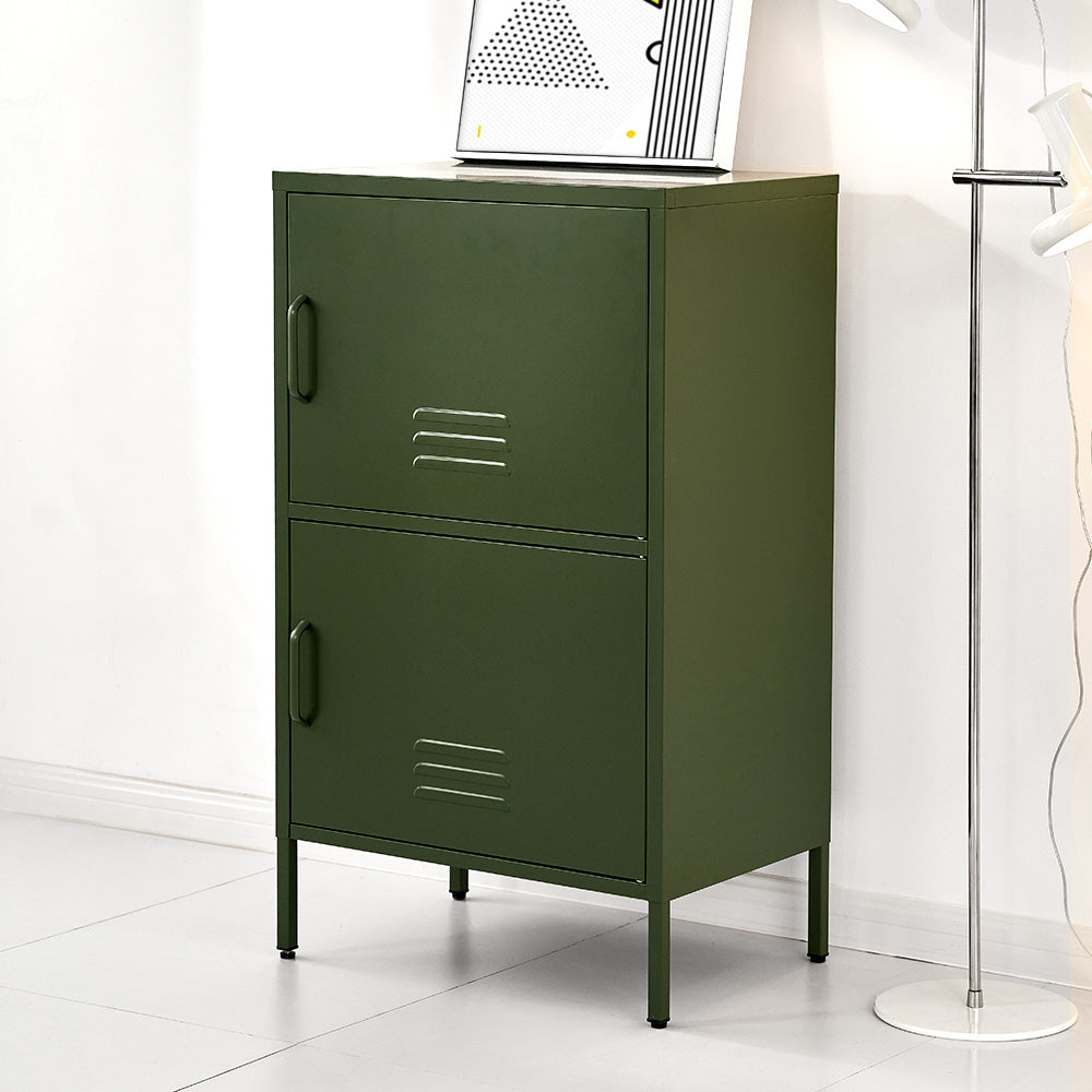 Dark green metal two-compartment stacked locker cabinet with art print on top beside floor lamp, angle view in room