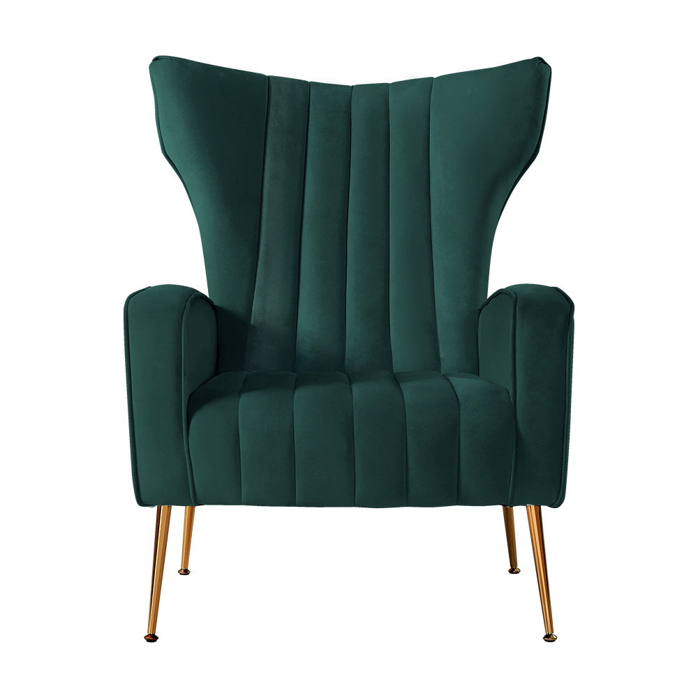 Dark green velvet wingback armchair with vertical channel tufting, flared wings, and gold metal tapered legs, front view