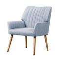 Light grey fabric accent chair with vertical channel stitching and tapered wood legs angle view on white background