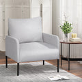 Light grey fabric armchair with black metal legs in living room with folding screen, side table with flowers and magazine