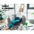 Woman lounging in grey fabric barrel armchair with legs over arm in modern room, text: Seated in comfort, Always a pleasure