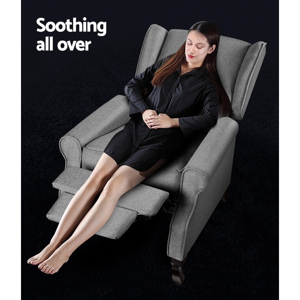 Grey fabric wingback recliner in fully reclined position with woman seated and footrest extended, Soothing all over text