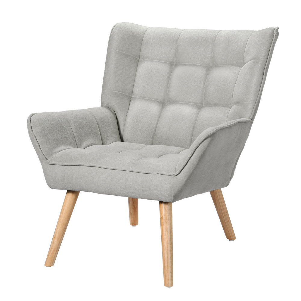 Light grey fabric grid-tufted wingback armchair with natural wood splayed legs angle view on white background