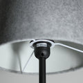 Close-up of black E27 MAX.60W bulb socket inside grey felt lamp shade with white wire and internal frame visible