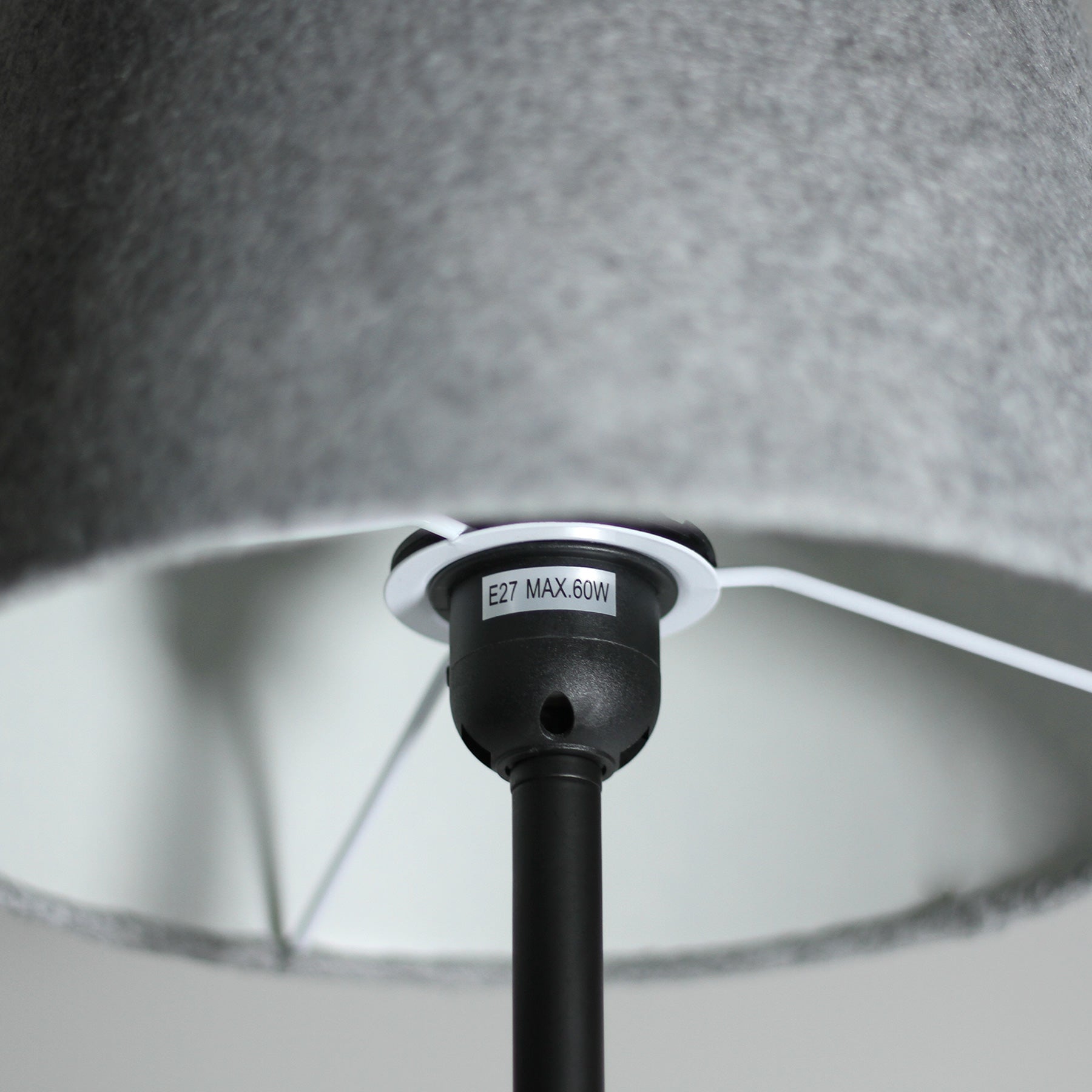 Close-up of black E27 MAX.60W bulb socket inside grey felt lamp shade with white wire and internal frame visible