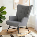 Grey linen button-tufted wingback rocking chair with black metal frame and wood runners in lifestyle room with plant