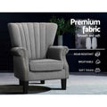Grey fabric nailhead wingback armchair in dark lifestyle room, badges: Premium fabric, Wear-resistant, Breathable, Soft touch