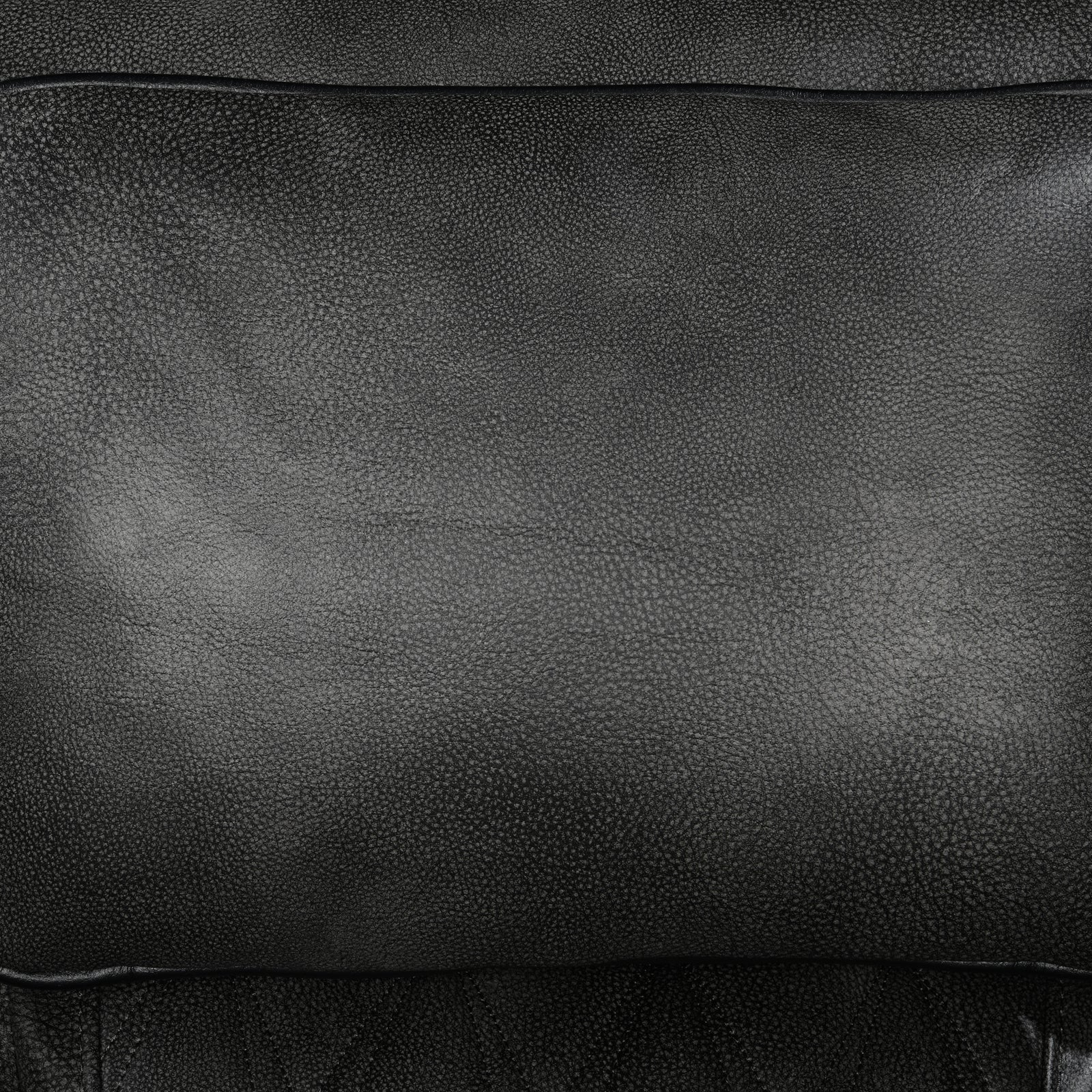 Close-up of dark charcoal pebbled leather seat cushion texture on power recliner