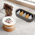 Grey ribbed oval ottoman with lid open showing cushions stored inside, styled in living room with rattan coffee table on rug