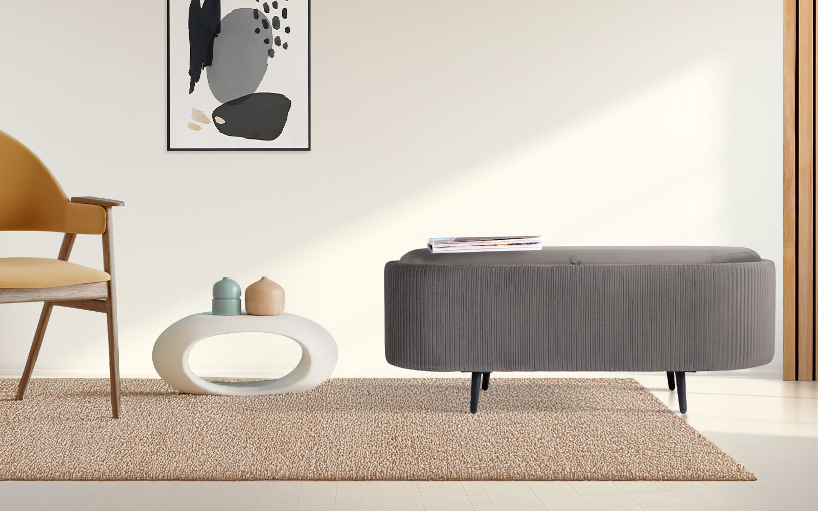 Grey ribbed oval storage ottoman with magazine on top, styled beside yellow armchair and white side table on beige rug