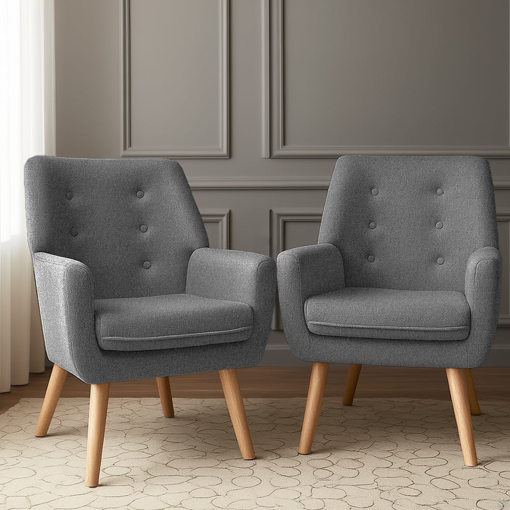 Pair of dark grey button-tufted fabric armchairs on patterned rug, grey panelled wall background