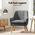 Dark grey tufted armchair in living room, 130kg capacity badge, 