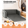 Grey velvet kids sofa bed extended in kids room with giraffe toy and feature icons