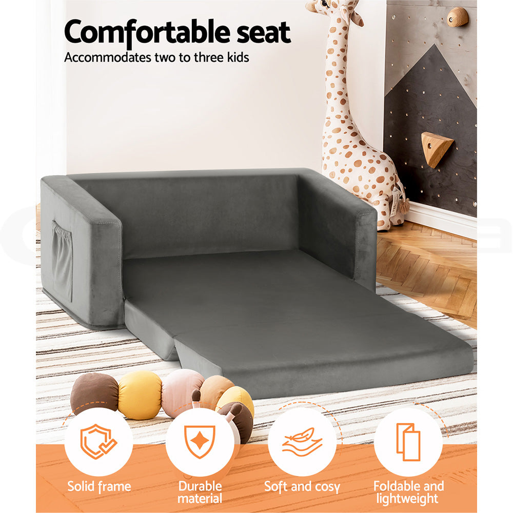 Grey velvet kids sofa bed extended in kids room with giraffe toy and feature icons