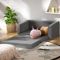 Grey velvet kids sofa bed fully extended flat in kids room with colourful worm toy and bookshelf