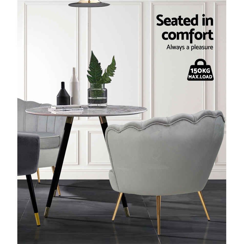 Grey velvet scallop shell armchair rear view at round marble table with 150kg max load badge in white panelled room