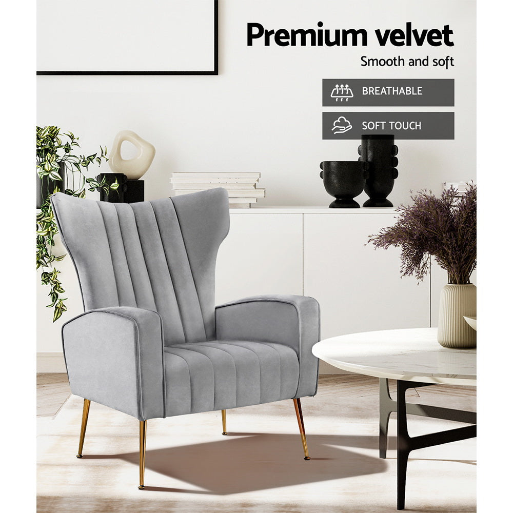 Grey velvet wingback armchair in lounge room with sideboard showing Premium velvet Breathable and Soft touch feature badges