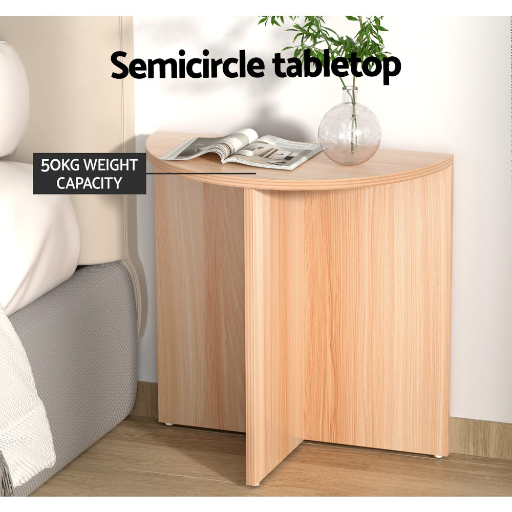 Half-moon side table beside bed, text: Semicircle tabletop, 50kg weight capacity, magazine and glass vase on top