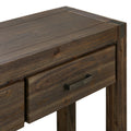 Close-up of dark wood hall table corner showing drawer with metal bar handle, metal corner bracket and wood grain