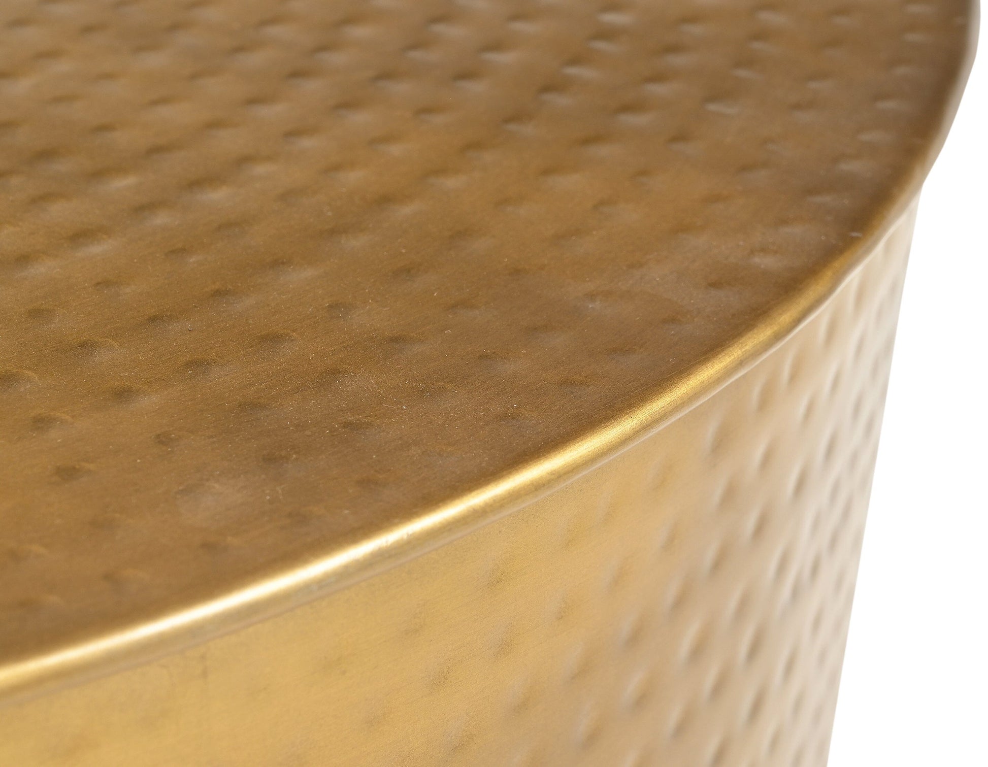 Extreme close-up top-down view of the hammered brass-finish surface of a round metal coffee table showing circular dot