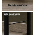 Close-up detail of industrial bookshelf showing grey oak shelf texture and black powder-coated metal frame cross brace