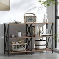 Three-tier industrial console table with dark walnut shelves and black X-frame sides, styled with books, speaker, plants