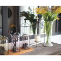 Industrial console table top styled with glass cloches, animal figurines, cage candle lantern and yellow flower vase