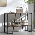 Industrial console table with dark walnut top and lower shelf, angled black metal frame, styled with speaker and baskets
