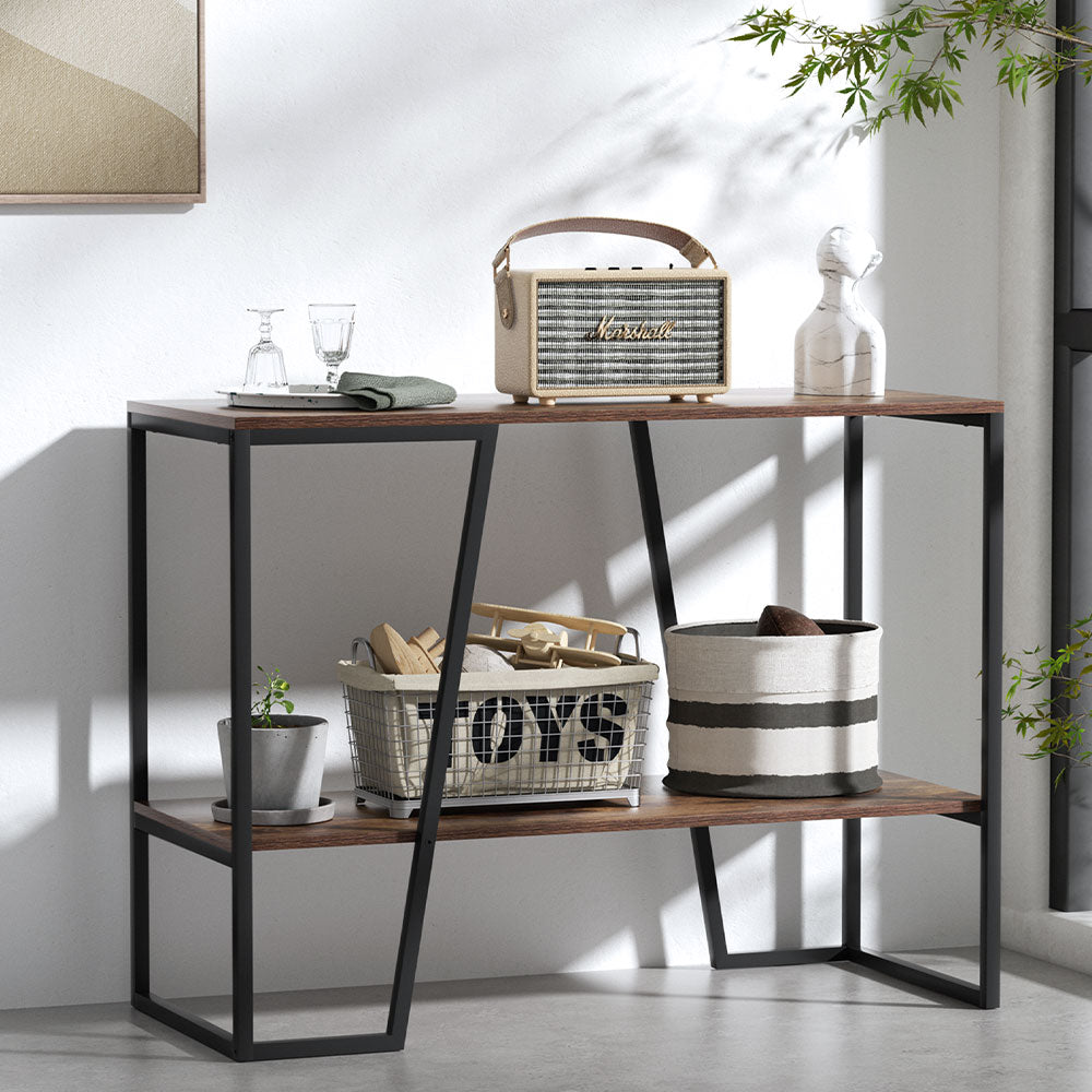 Industrial console table with dark walnut top and lower shelf, angled black metal frame, styled with speaker and baskets