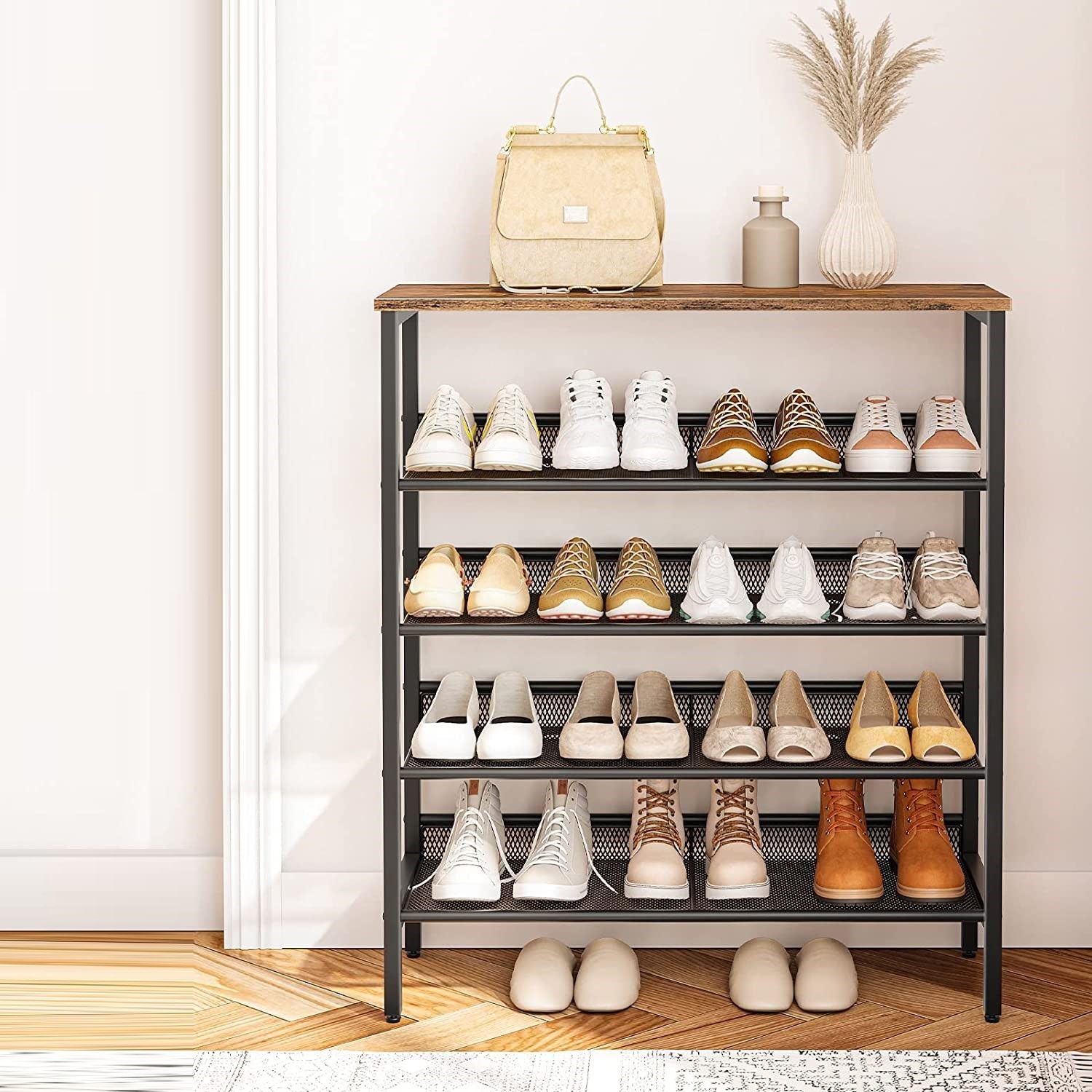 Industrial mesh 4-tier rack fully loaded with shoes and boots in hallway, handbag and vases on wood top